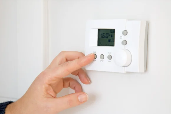 Hand stellt Heizung ein